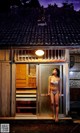 A woman in a white bikini standing in front of a door.