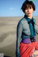 A woman standing in the middle of a desert.