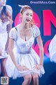 A group of young women in white dresses on stage.