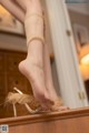 A woman's feet in high heels on a dresser.