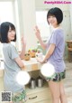 A couple of women standing next to each other in a kitchen.