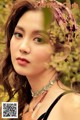 A woman wearing a headband and a necklace in a field.