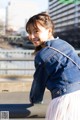 A young woman wearing a pink tulle skirt and a denim jacket.