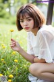 A woman sitting in a field of yellow flowers.