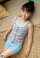 A young girl laying on a bed wearing a blue and white striped top.