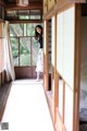 A woman standing in a room with a tatami mat.