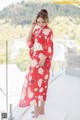 A woman in a red kimono standing on a balcony.